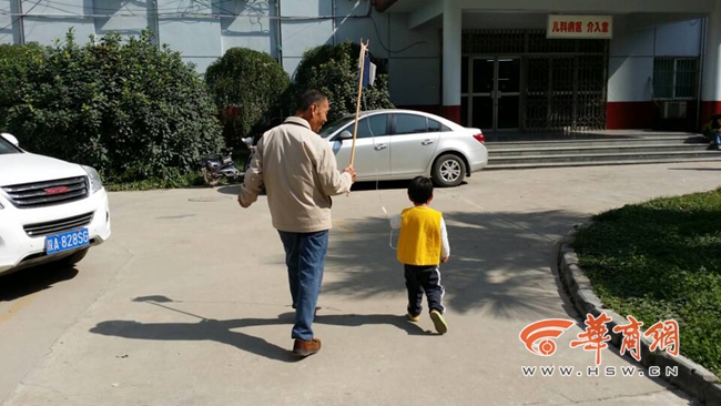 爷爷挑着吊瓶带孙子室外晒太阳 医生称不妥