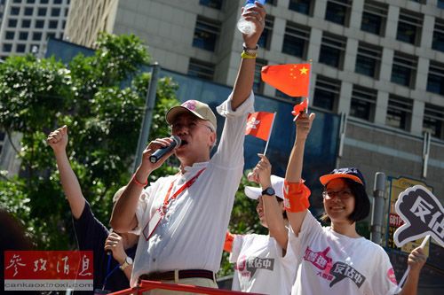 资料图片：2014年8月17日，香港“保普选、反占中大联盟”发言人周融（前）在“和平普选大游行”终点处向游行队伍致意。新华社记者赵丹惠摄