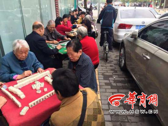 居民在报恩寺街人行道上打麻将 路人难通过