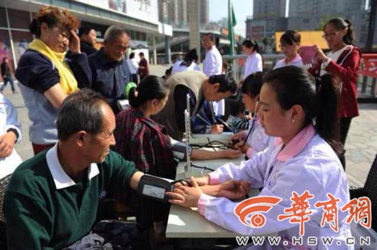 西安高校学生志愿者广场宣传新《环保法》