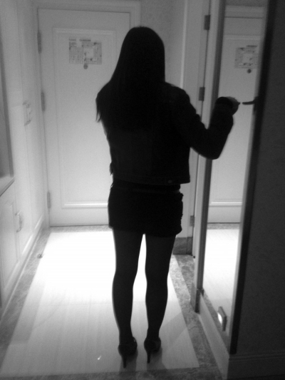 被叫至记者房中的女子正在打电话。