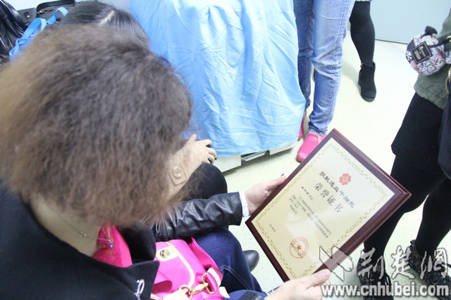 老师和同学看着中华骨髓库颁发给李炳昊的荣誉证书。