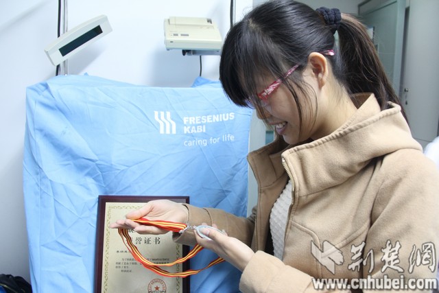 老师和同学看着中华骨髓库颁发给李炳昊的荣誉证书。