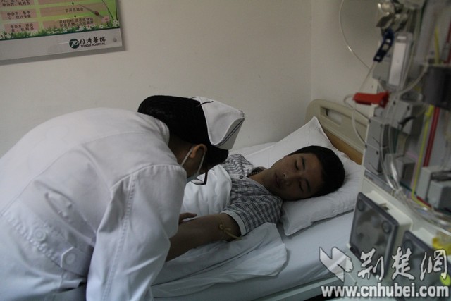  李炳昊安静的躺在床上看着护士检查他的血管。