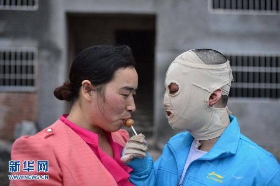 周涛拿着一根棒棒糖喂给妈妈吃。