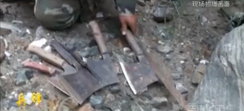 战士们从恐怖分子的随身物品中搜出了刀斧、地图和“圣战”旗帜等物品。