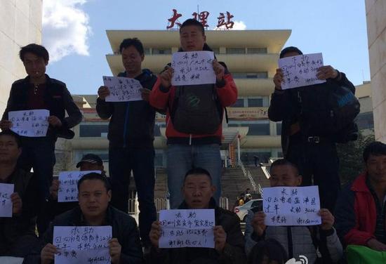 大理火车站，没钱买车票的民工们举牌向好心人寻求帮助