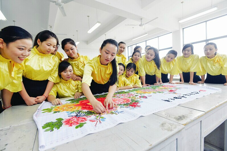 淑女班讲究“内外兼修”，学员必须要学艺术修养、化妆技巧、公关礼仪、形体训练、国学经典、剪纸艺术、书法、手工编织等课程，共211个学分才算合格。图为：十字绣实训。