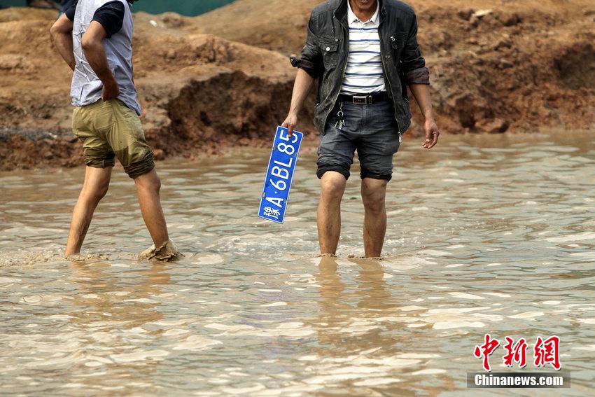 郑州一路段现百米积水 捞车牌成“生意”